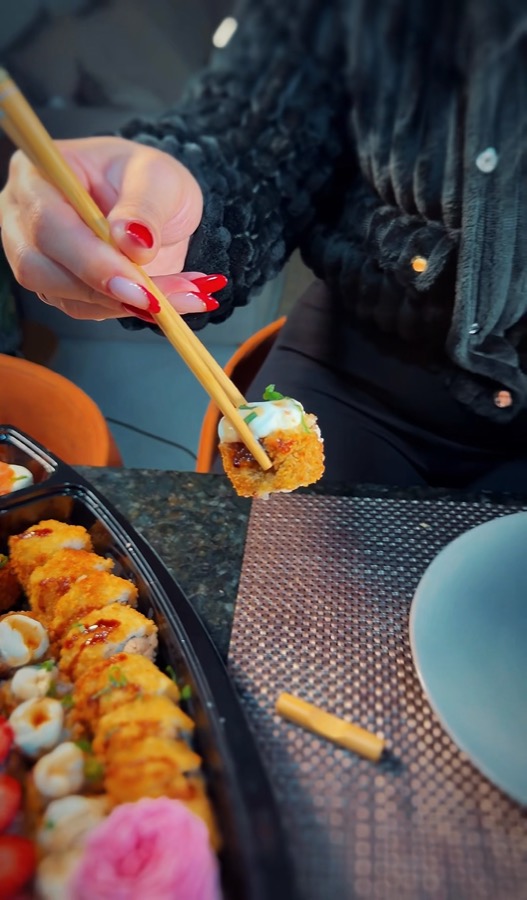 Hashi molhando o hot roll no shoyu